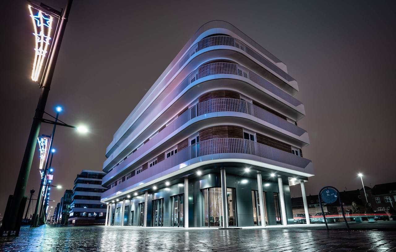 our-services-3 Futuristic modern building illuminated at night in an urban setting.